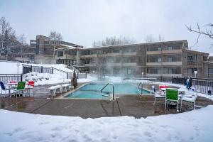 斯诺马斯村波克罗蒂旅舍的一座建筑物前的积雪覆盖的游泳池
