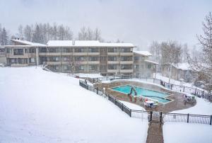 斯诺马斯村波克罗蒂旅舍的一座在雪中设有游泳池的建筑