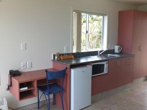 阿希帕拉Ahipara Bay Motel的厨房配有柜台、水槽和窗户
