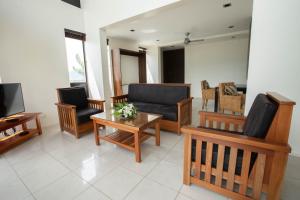 拉奇拉奇Dreamview Villas的客厅配有沙发、椅子和电视