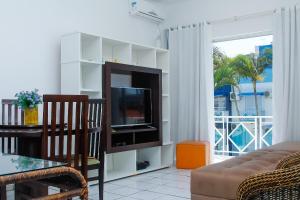 Apto a 70 metros da praia, Piscina, 03 Ar Condicionados, Vaga de Garagem的电视和/或娱乐中心