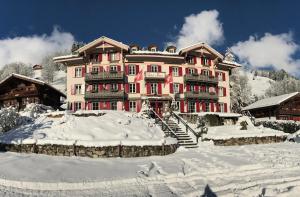 莱迪亚布勒雷Historic Hotel du Pillon的前面有雪的大建筑