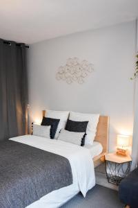 伊兰柯尔特La Clef d'Aurélia的卧室配有一张带白色床单和枕头的大床。