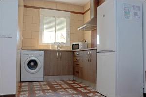 科尼尔-德拉弗龙特拉Chalet Muelle Pesquero 65的厨房配有洗衣机和冰箱。