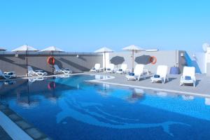 阿布扎比爱迪萨瓦酒店公寓的一个带椅子和遮阳伞的游泳池
