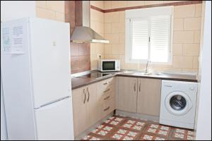 科尼尔-德拉弗龙特拉Chalet Muelle Pesquero 66的厨房配有白色冰箱和洗衣机。