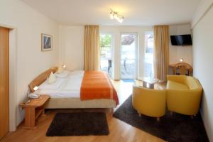 基尔泽格哈芬酒店的一间卧室配有一张床、一张桌子和一把椅子
