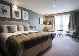 贝弗利The Beverley Arms Hotel的一间卧室配有一张大床和一把椅子