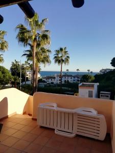 福恩吉罗拉Club La Costa World Resort的阳台享有大海和棕榈树的景致。