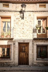 锡古恩萨Casa La Alegria De La Alcarria II的一座石头建筑,设有两扇门和两扇窗户