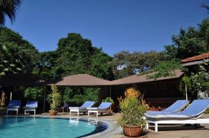 内罗毕La Mada Hotel的一个带躺椅和遮阳伞的游泳池