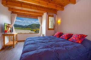 圣马丁德洛斯Cabañas Del Lacar的一间卧室设有蓝色的床和大窗户