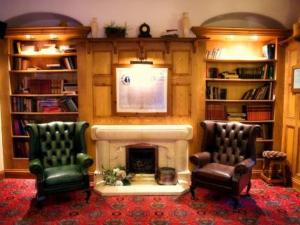 索恩The Punchbowl Inn的客厅配有两把椅子和壁炉