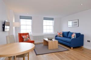 爱丁堡Destiny Scotland New Town Apartments的客厅配有蓝色的沙发和桌子
