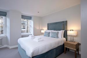 爱丁堡Destiny Scotland New Town Apartments的一间卧室设有一张大床和两个窗户。