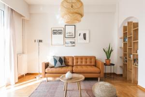 雅典Central Cozy Apartments in Plaka by UPSTREET的客厅配有棕色沙发和桌子