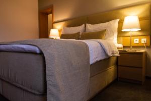 塞内奇马拉松酒店的一间卧室配有一张大床和两盏灯。