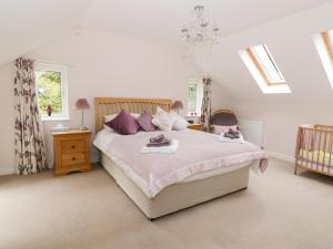 诺里奇Cherry Tree Cottage的一间卧室配有一张带紫色枕头的大床