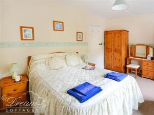 MoretonBrickyard Cottage的一间卧室配有一张带蓝色毛巾的床