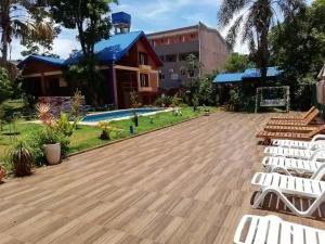 伊瓜苏港Hotel Amayal的一个带白色椅子的甲板和游泳池