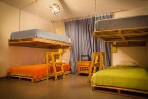 波哥大Bababuy Hostel的一间卧室配有两张床和两张凳子