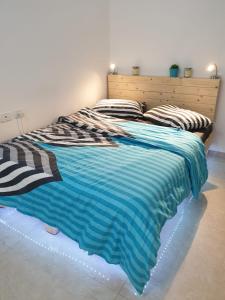 Beʼer Oraסויטה בלב המדבר.的床上有蓝色和白色的毯子