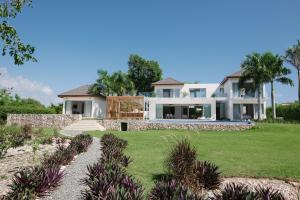 蓬塔卡纳Villa "Bella Luna"的一座带草地庭院的大型白色房屋