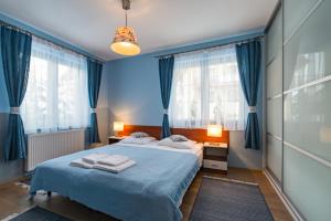 什恰夫尼察Apartamenty Tyrol的蓝色的卧室,配有床和蓝色窗帘