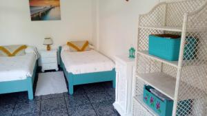 波多·纳奥斯Mi apartamento Mini 2的一间卧室设有两张单人床和一个架子