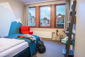 雷克雅未克Loft - HI Eco Hostel的卧室配有床、椅子和窗户。