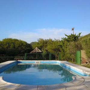卡皮亚德尔德尔蒙特Cabañas El Aguaribay的庭院里的一个蓝色海水游泳池