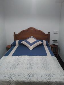 Corras de la PuenteCasa Gelina的一间卧室配有一张带蓝色和白色棉被的床