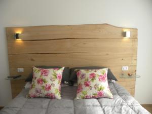 克里日亚科尔特德尔加洛酒店的一张带两个枕头的床和木制床头板
