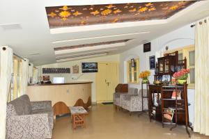 乌提KSTDC Hotel Mayura Sudarshan ,Ooty的带沙发和椅子的客厅以及天花板