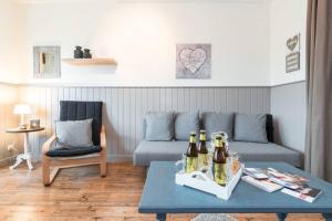 布鲁日Charmant appartement met zicht Damse vaart @Brugge的带沙发的客厅和桌子上的啤酒瓶