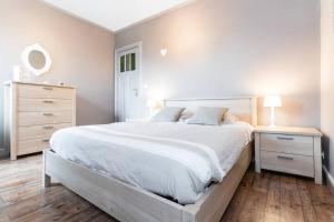 布鲁日Charmant appartement met zicht Damse vaart @Brugge的白色卧室设有一张大床和一个梳妆台