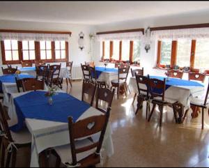 坎伯雷塔Las Verbenas Hotel的一间设有蓝色桌椅和窗户的用餐室
