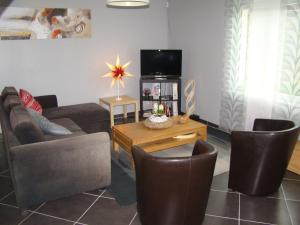 Fresnicourt-le-Dolmenle gite d'olhain的客厅配有沙发、椅子和电视