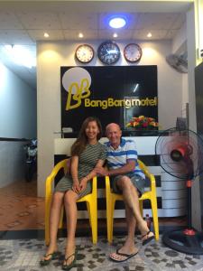 芹苴BangBang Motel的坐在商店黄色椅子上的男人和女人