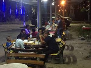梭桃邑Navy Home Sattahib的一群坐在餐桌上过夜吃饭的人