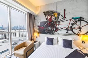 吉隆坡吉隆坡维瓦特尔酒店的卧室配有一张床,墙上有自行车