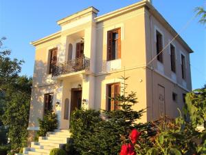 安吉斯乔治亚斯尼拉Vogiatzopoulou Guesthouse的前面有楼梯的黄色建筑