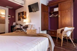 圣维托罗卡波Hotel Pocho的卧室设有紫色墙壁、一张床和一把椅子