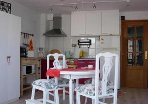 阿利坎特Calablu的厨房配有红色桌子和两把白色椅子