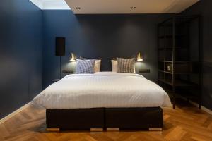 阿姆斯特丹The Blossom House Amsterdam的一间卧室配有一张带蓝色墙壁的大床