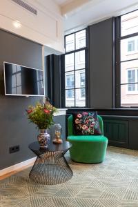阿姆斯特丹The Blossom House Amsterdam的客厅配有绿色椅子和桌子