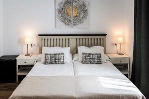 阿兰约兹Posada de la Costurera de Aranjuez的一间卧室配有一张带两盏灯的大型白色床。