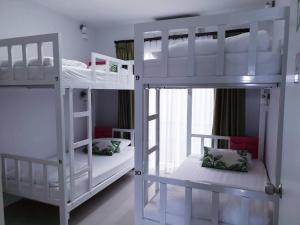 蔻立DKaYa旅舍的带窗户的客房内的2张白色双层床