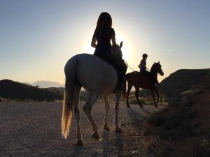HinojaresHotel Rural Valle del Turrilla - Cazorlatur的两个人在土路上骑马
