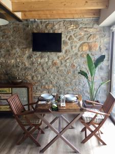 索特雷斯La Cabaña de Catalina的一张桌子、两把椅子和一台石墙电视
